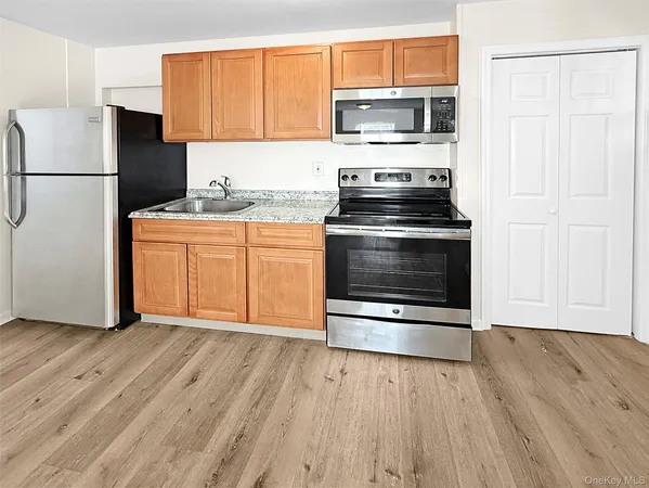 a kitchen with granite countertop a refrigerator stove and microwave