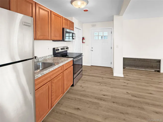 a kitchen with stainless steel appliances granite countertop a refrigerator a stove and a microwave