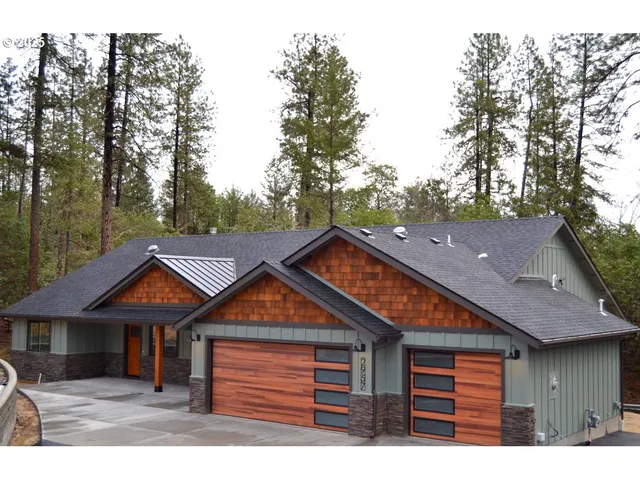 a view of an empty room with wooden floor and a fireplace