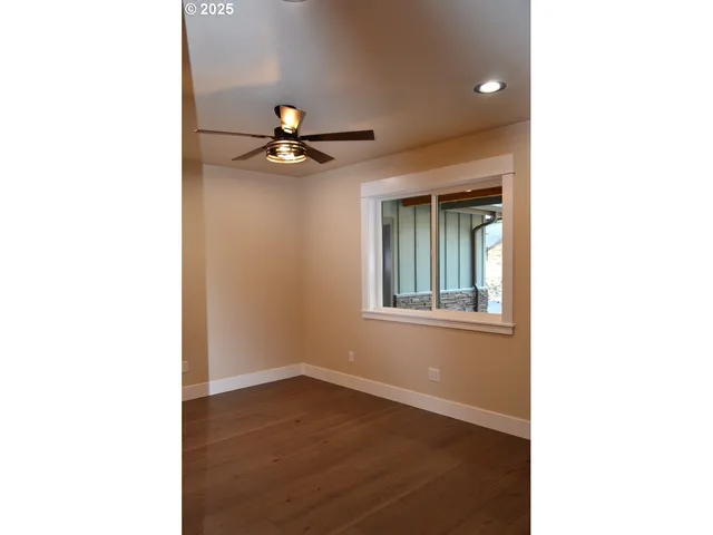 a view of empty room with wooden floor