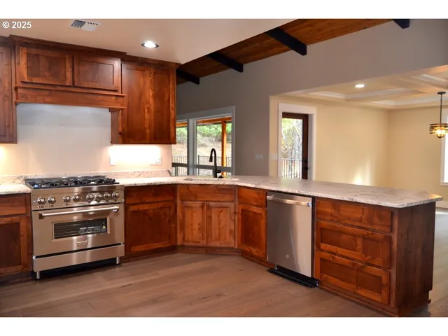 a kitchen with stainless steel appliances granite countertop a refrigerator and a sink