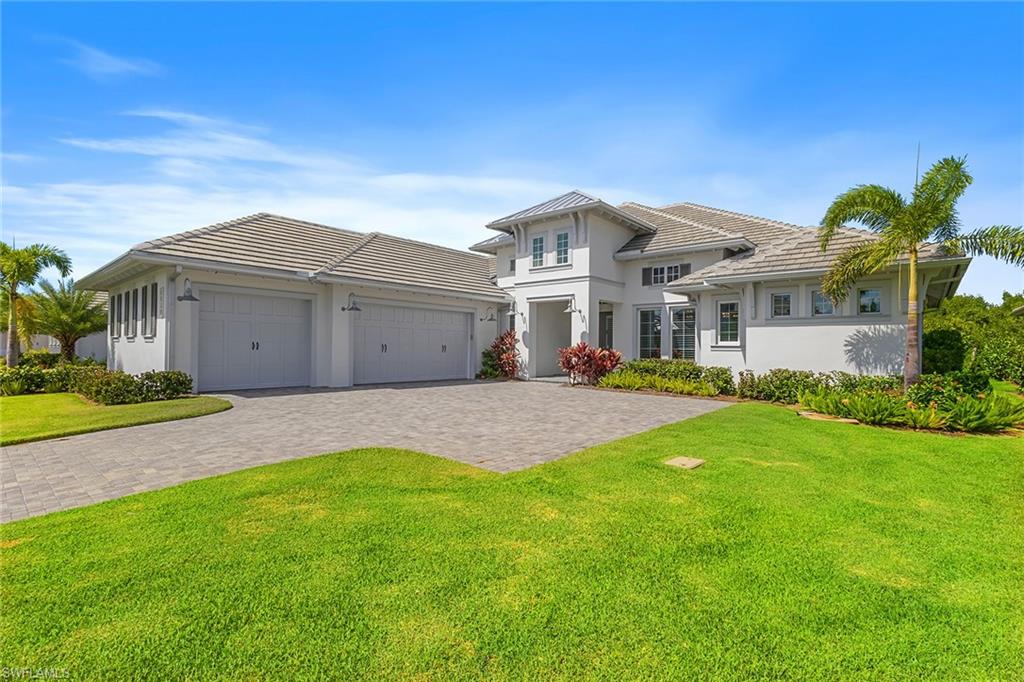 8829 Paradera Court Naples, FL 34112 - Photo 2 of 31 a front view of a house with a garden and yard