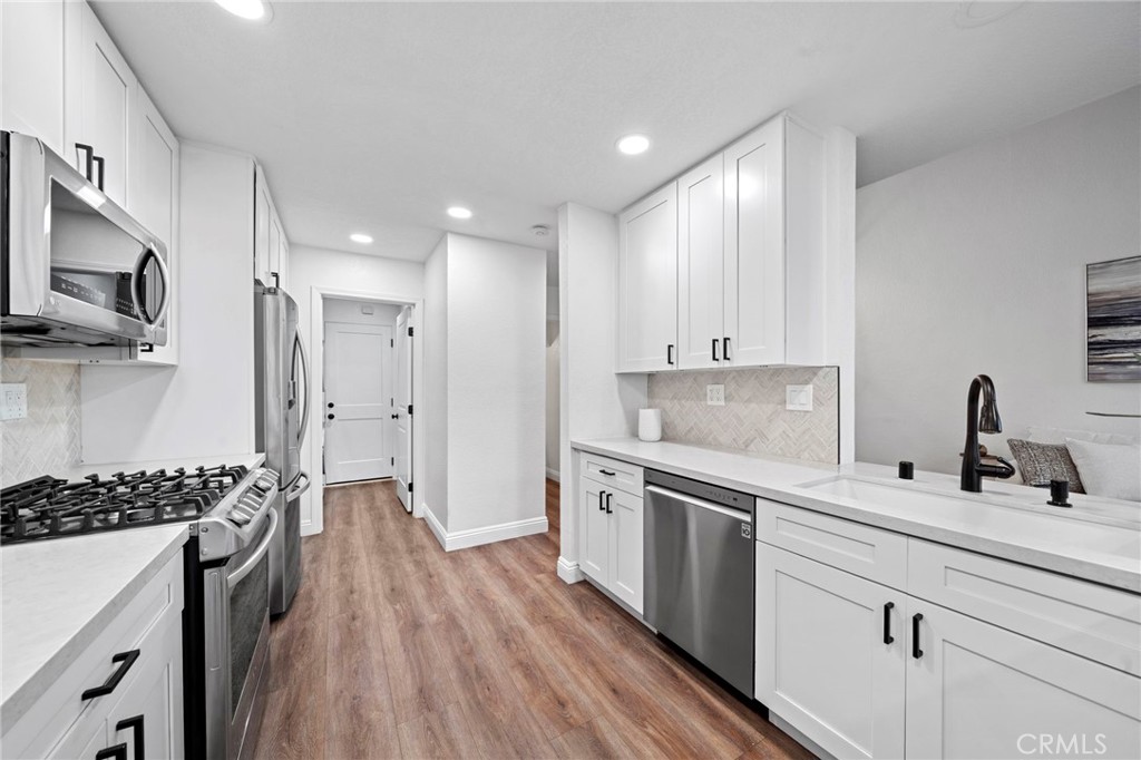 13615 Almond Street Tustin, CA 92782 - Photo 13 of 54 a kitchen with a sink stove and refrigerator
