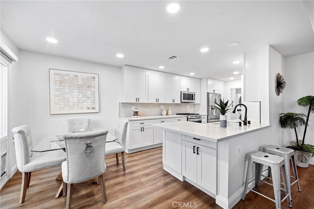 13615 Almond Street Tustin, CA 92782 - Photo 9 of 54 a kitchen with white cabinets and chairs