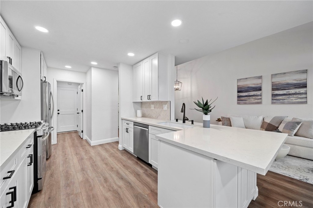 13615 Almond Street Tustin, CA 92782 - Photo 10 of 54 a kitchen with a sink a stove a refrigerator and cabinets