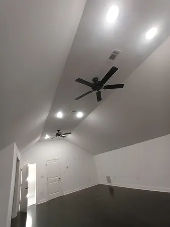 an empty room with a ceiling fan and wooden floor