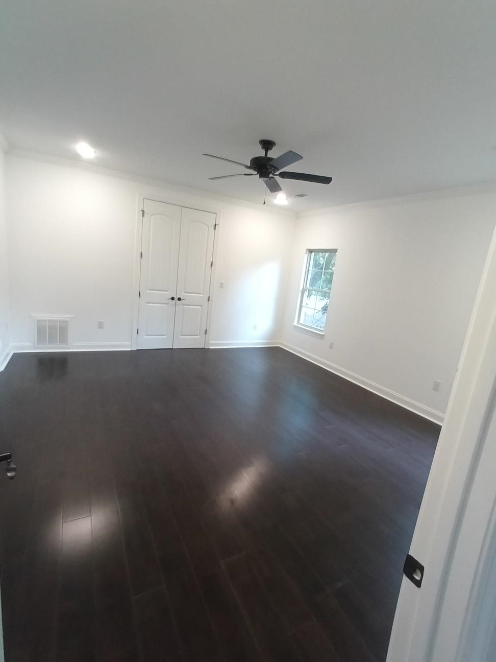 5690 Walnut Grove Road Memphis, TN 38120 - Photo 25 of 40 an empty room with a ceiling fan and wooden floor