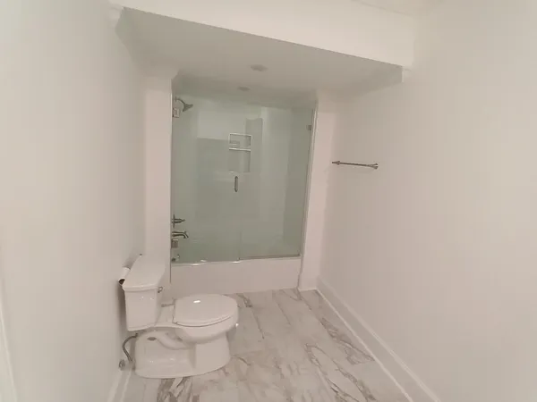 a bathroom with a granite countertop toilet and a shower