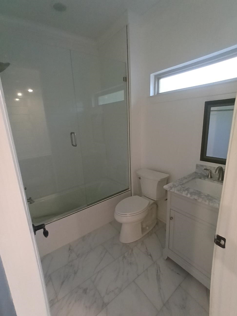 5690 Walnut Grove Road Memphis, TN 38120 - Photo 36 of 40 a bathroom with a granite countertop toilet and a shower