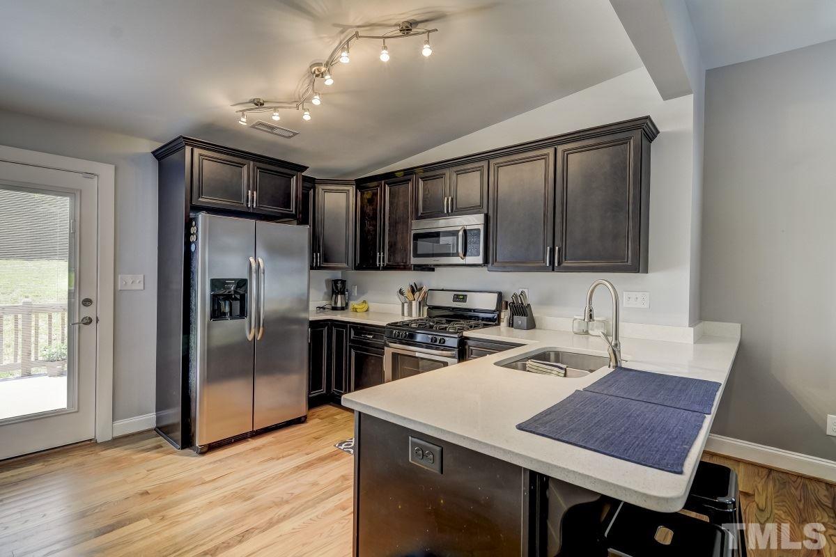 520 Alston Street Raleigh, NC 27601 - Photo 3 of 15 a kitchen with granite countertop a stove refrigerator and microwave