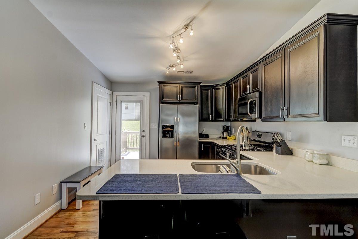 520 Alston Street Raleigh, NC 27601 - Photo 4 of 15 a room with table chairs cabinets and stainless steel appliances