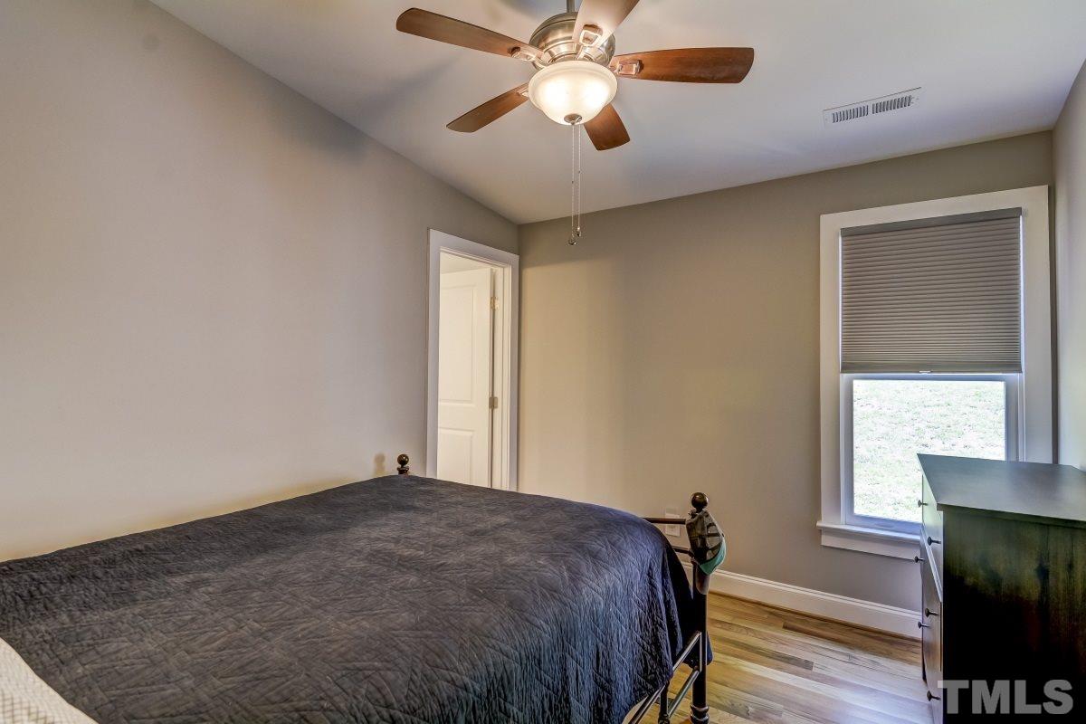 520 Alston Street Raleigh, NC 27601 - Photo 5 of 15 a bedroom with a bed and a chandelier