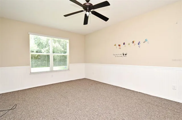 a view of a room with a window and a ceiling fan