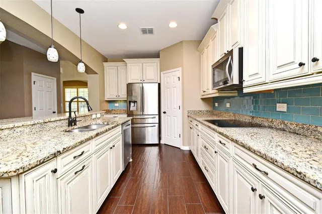 a kitchen with granite countertop cabinets stainless steel appliances and a counter space