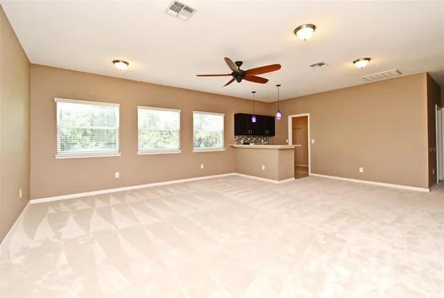 a view of a livingroom with a ceiling fan and window