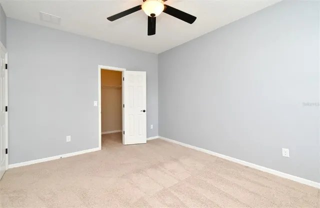 a view of a house with a big yard and large trees