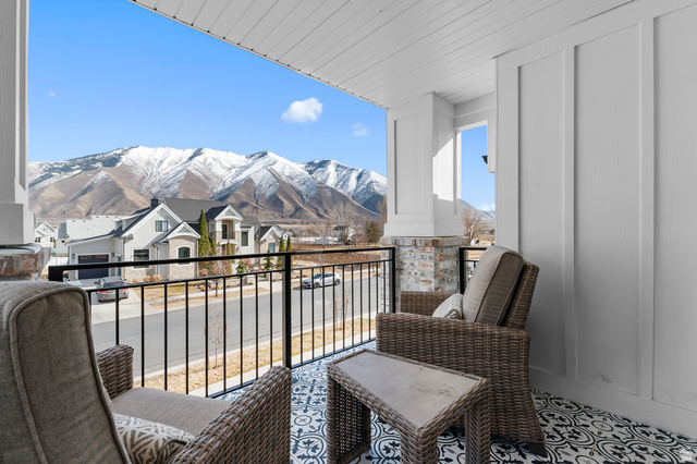 1426 South 1450th Street West Mapleton, UT 84664 - Photo 42 of 50 Covered balcony featuring black and white patterned tile flooring, a black metal railing, and white board and batten wall paneling