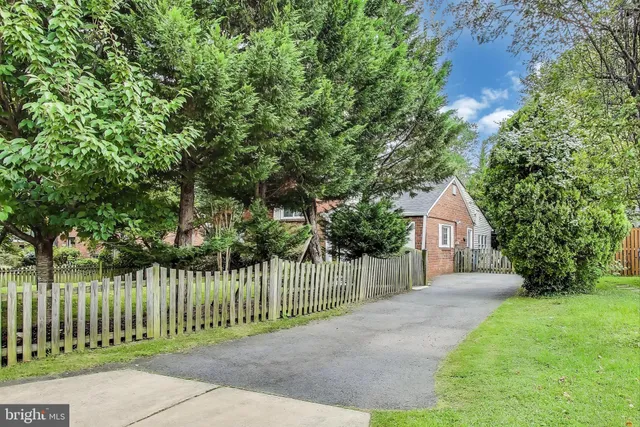 a view of a house with a small yard and wooden fence