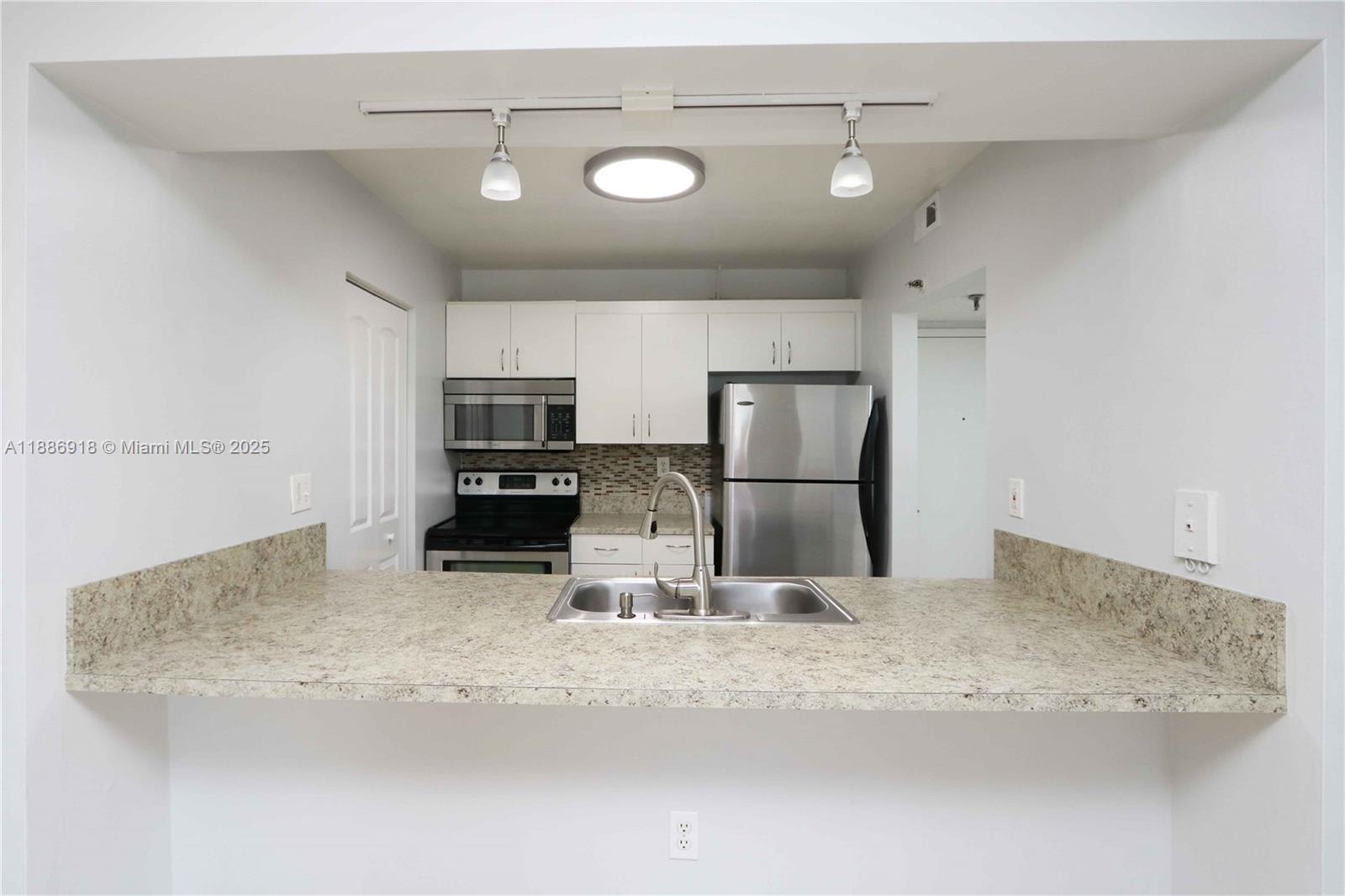 850 North Miami Avenue, Unit W305 Miami, FL 33136 - Photo 11 of 27 a kitchen with kitchen island a refrigerator sink and stove