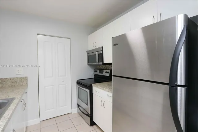 a white refrigerator freezer and a stove sitting inside of a kitchen
