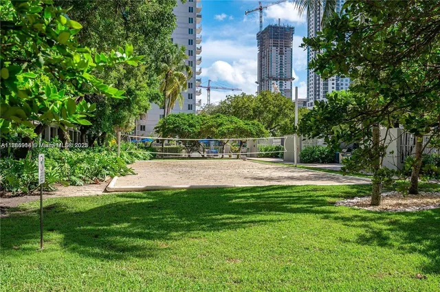 a view of a building with a big yard and large trees