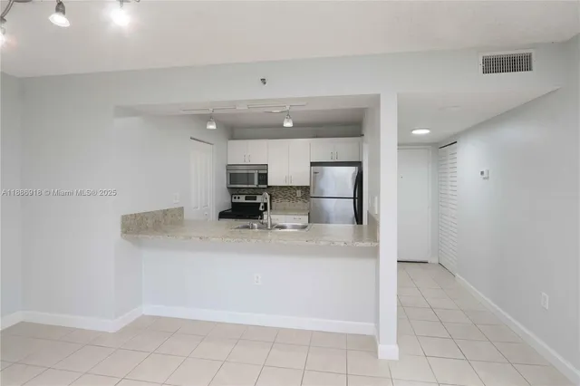 a view of kitchen with stainless steel appliances a refrigerator and a counter top space