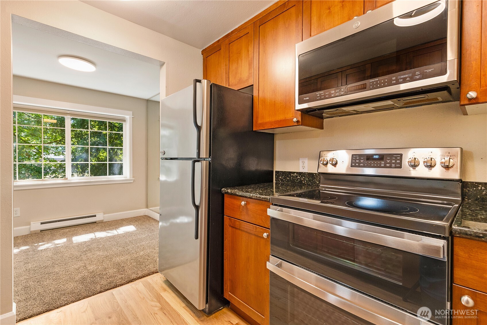 755 5th Avenue Northwest, Unit D202 Issaquah, WA 98027 - Photo 14 of 25 a kitchen with stainless steel appliances granite countertop a refrigerator and a stove top oven