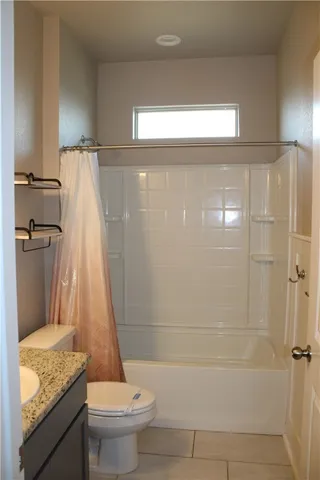 a bathroom with a granite countertop shower a toilet and a sink