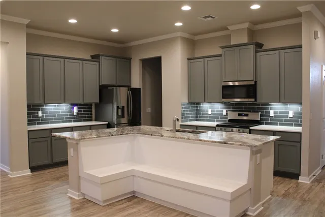 a kitchen with kitchen island a sink stainless steel appliances and cabinets