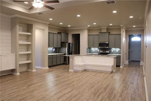 a large kitchen with kitchen island a sink stainless steel appliances and cabinets