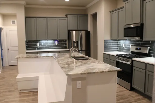 a kitchen with kitchen island a sink stove and refrigerator