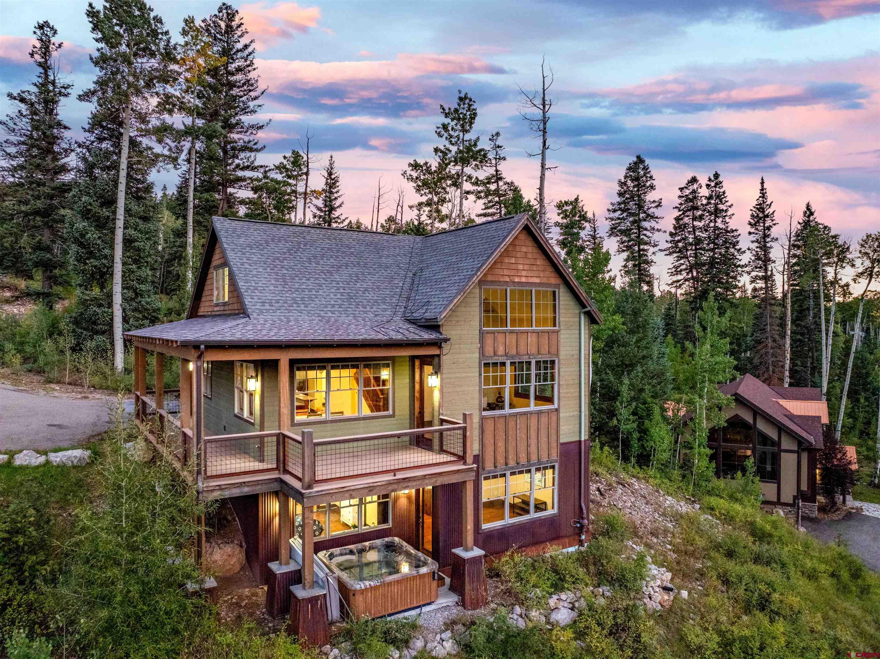 an aerial view of a house with balcony and trees al around
