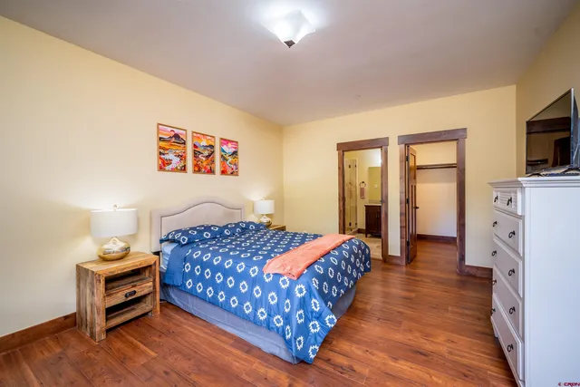 a bedroom with bed and wooden floor