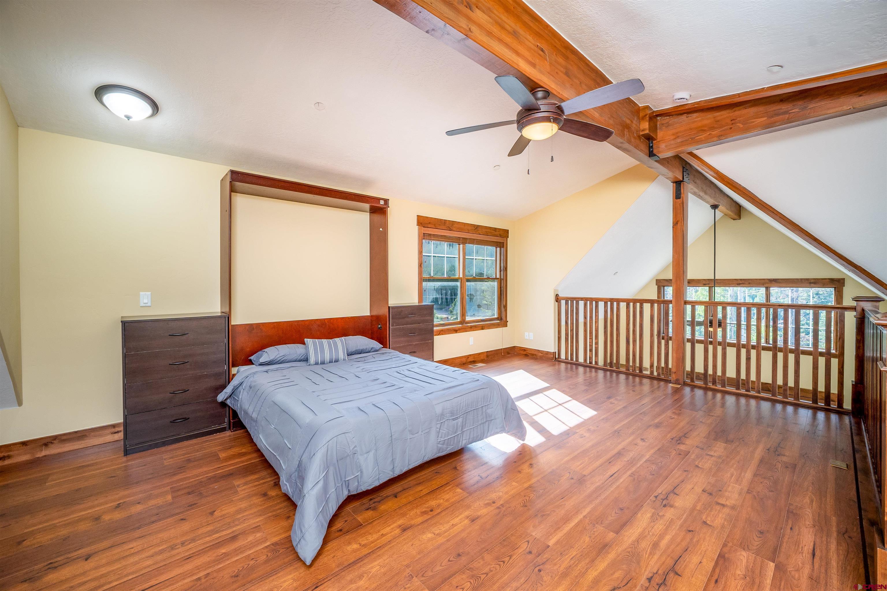 259 Engineer Drive Durango, CO 81301 - Photo 18 of 40 a bedroom with a bed and wooden floor