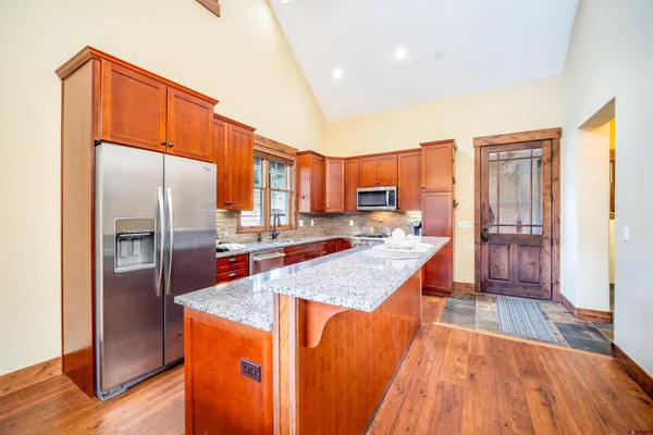 a kitchen with stainless steel appliances granite countertop a refrigerator a sink and a stove