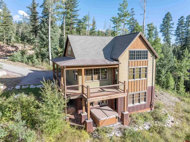 an aerial view of a house with yard and trees