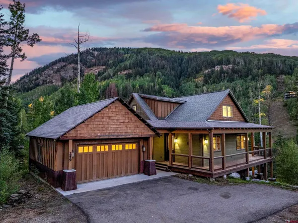 a front view of a house with a yard balcony and outdoor seating