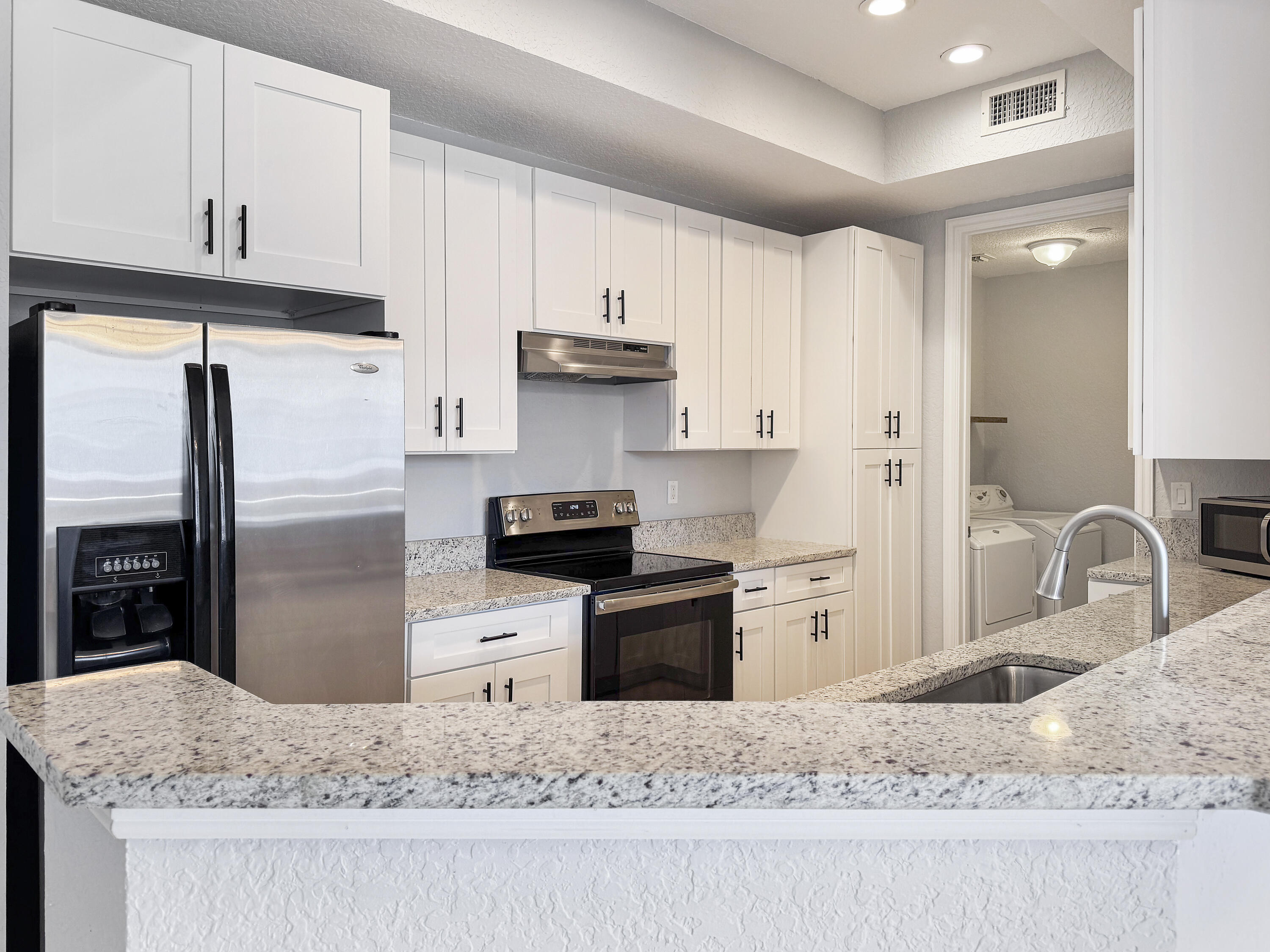 10560 Southwest Stephanie Way, Unit 1206 Port St. Lucie, FL 34987 - Photo 1 of 23 a kitchen with stainless steel appliances granite countertop a refrigerator a stove and a sink