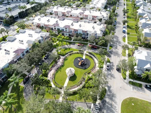 an aerial view of a swimming pool with a yard and plants