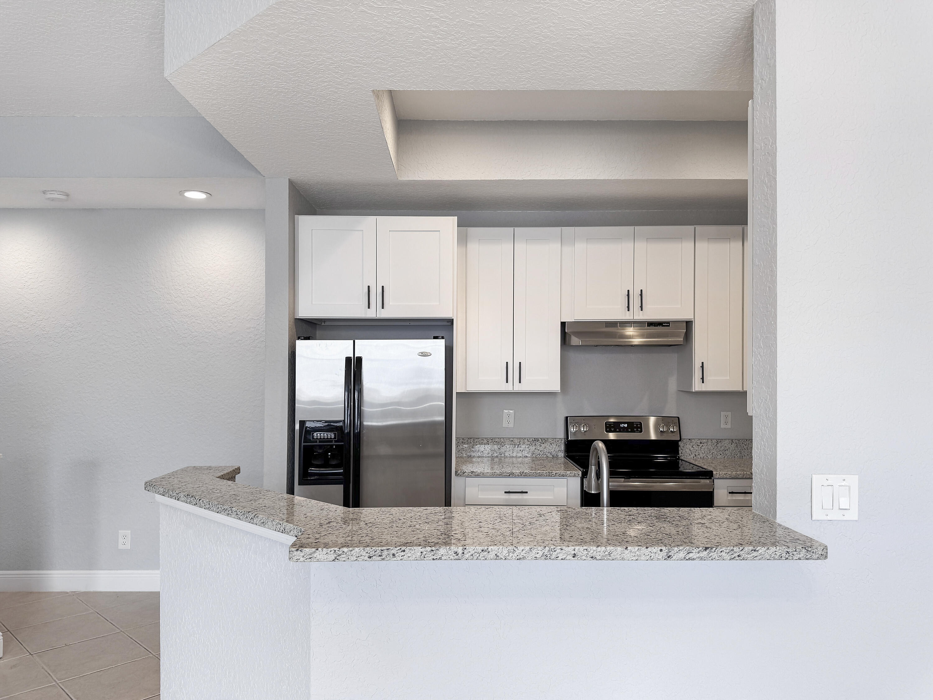 10560 Southwest Stephanie Way, Unit 1206 Port St. Lucie, FL 34987 - Photo 4 of 23 a kitchen with stainless steel appliances granite countertop a sink a stove and a refrigerator