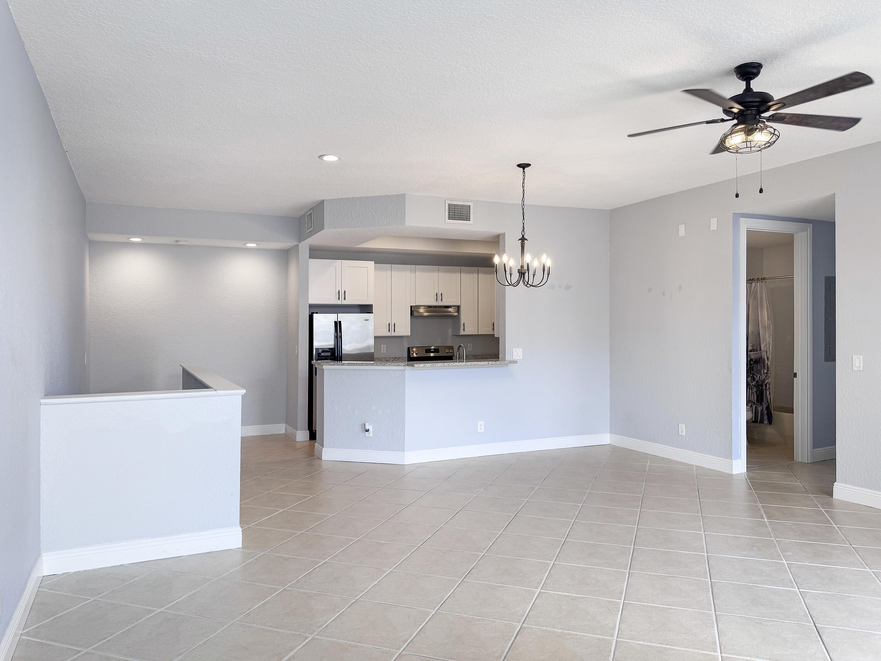 10560 Southwest Stephanie Way, Unit 1206 Port St. Lucie, FL 34987 - Photo 7 of 23 a view of a kitchen with a sink and a ceiling fan
