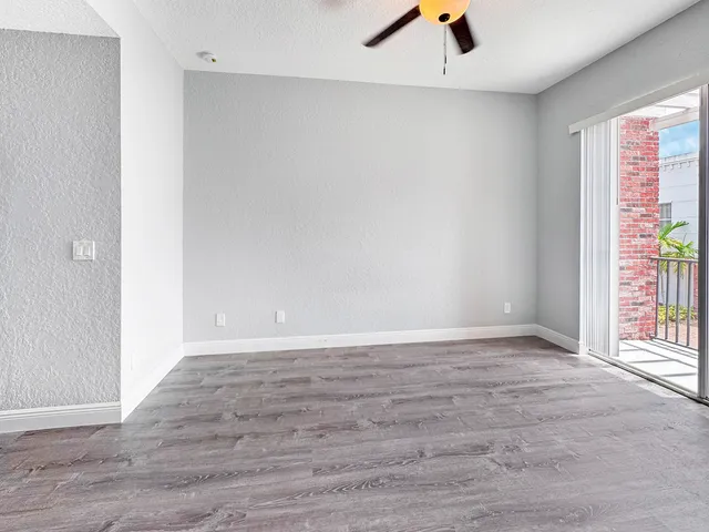 an empty room with window and a ceiling fan