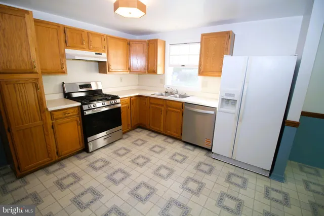 a kitchen with granite countertop a sink stove and refrigerator