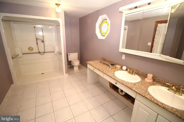 a spacious bathroom with a granite countertop sink and a mirror