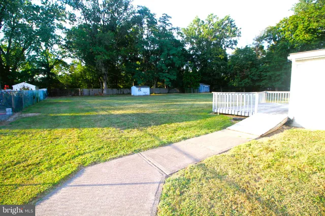 a view of backyard with swimming pool and green space