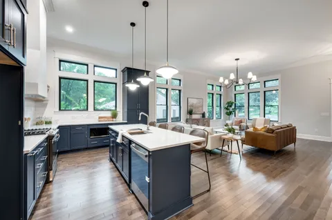 a large kitchen with kitchen island a stove a sink a center island a dining table and chairs