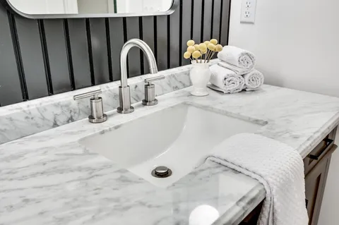 a bathroom with a granite countertop sink and a mirror