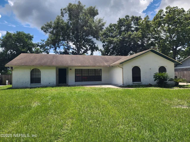 a front view of house with yard and trees