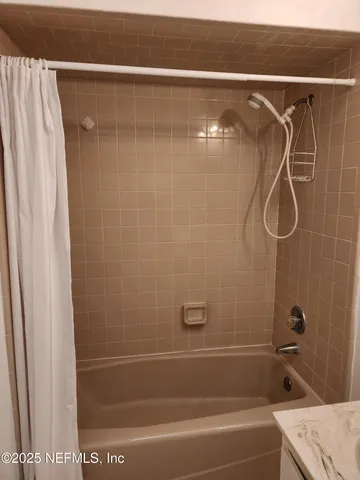 a bathroom with a shower and a bath tub