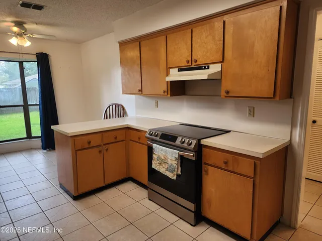 a utility room with stainless steel appliances granite countertop a stove a sink and a microwave